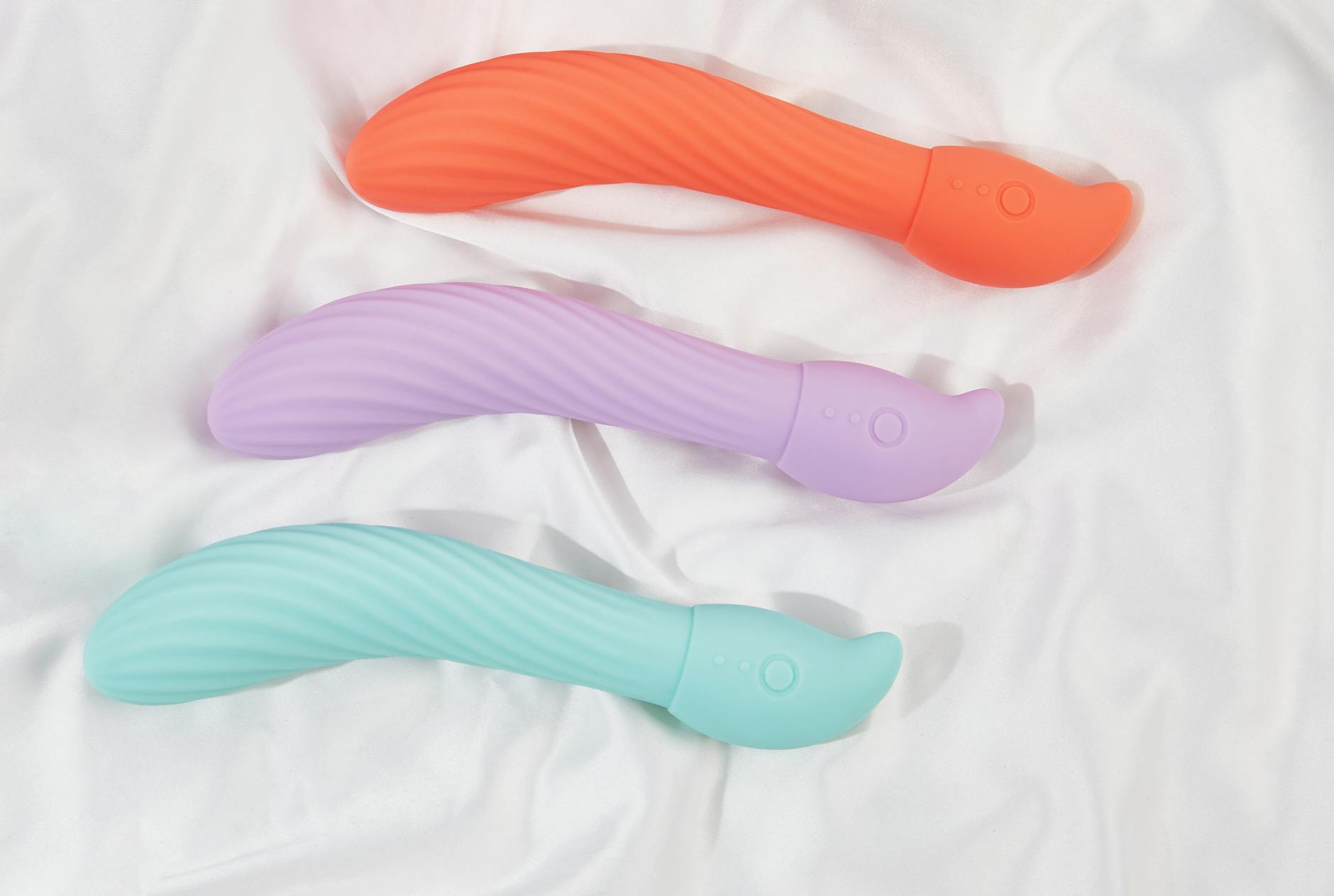 Colorful lemon vibrators and sex toys arranged on a bright yellow background in a studio setting