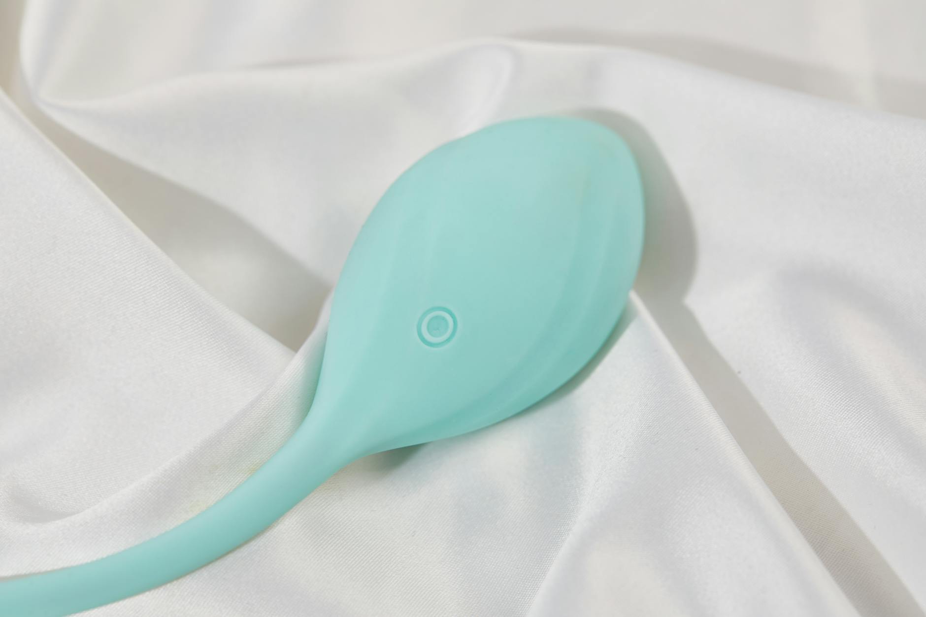 A stylish clitoral vibrator on soft white fabric