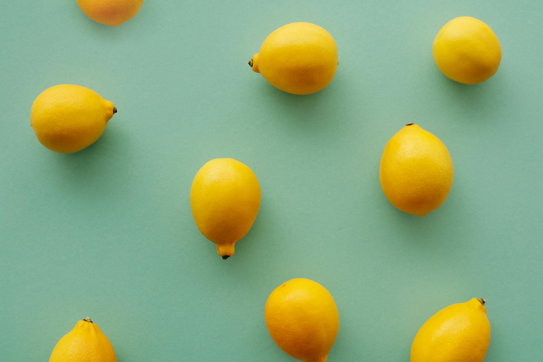Bright yellow lemons on a pastel green background, symbolizing freshness and new beginnings