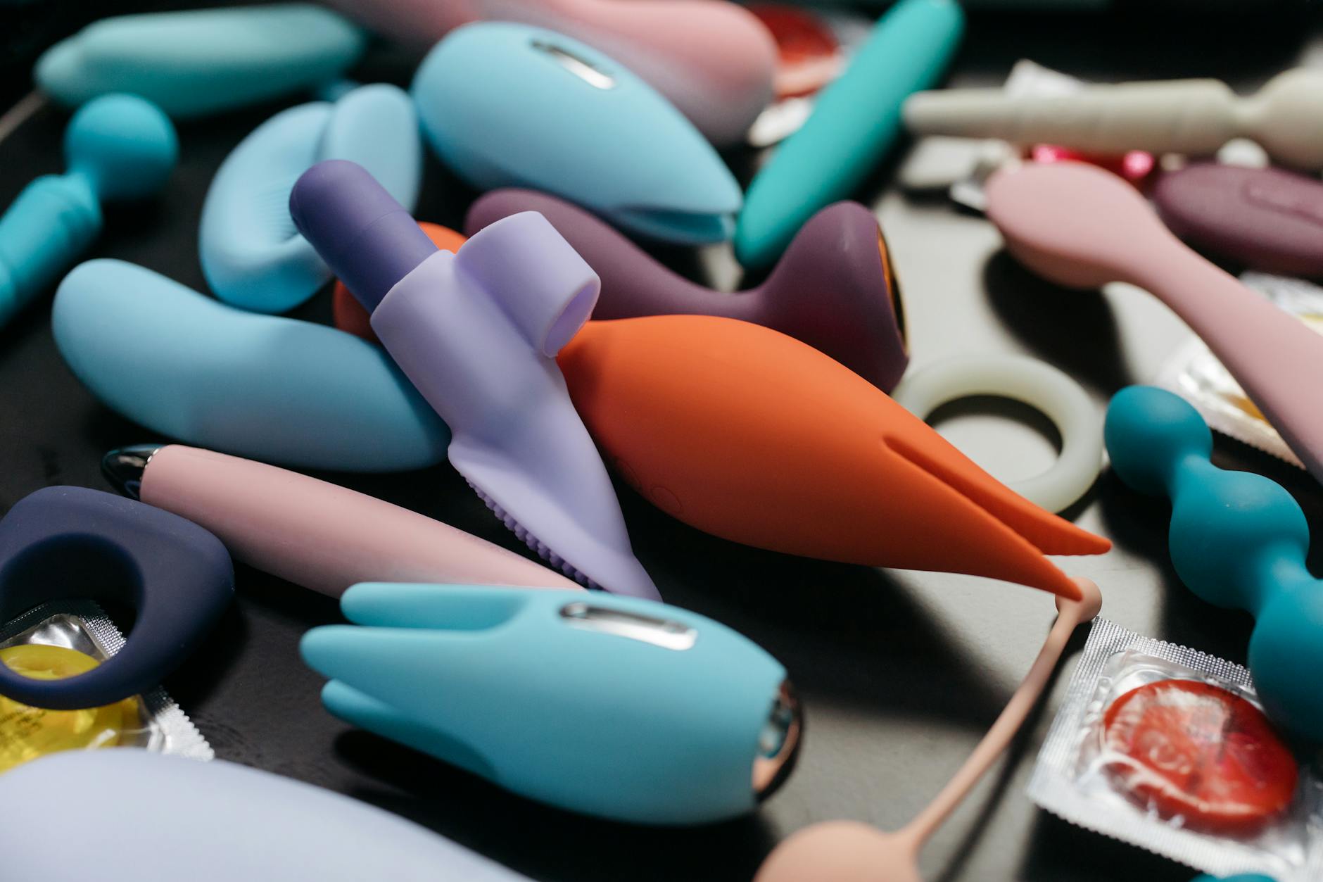 Woman holding blue and pink silicone vibrators, demonstrating pelvic health tools