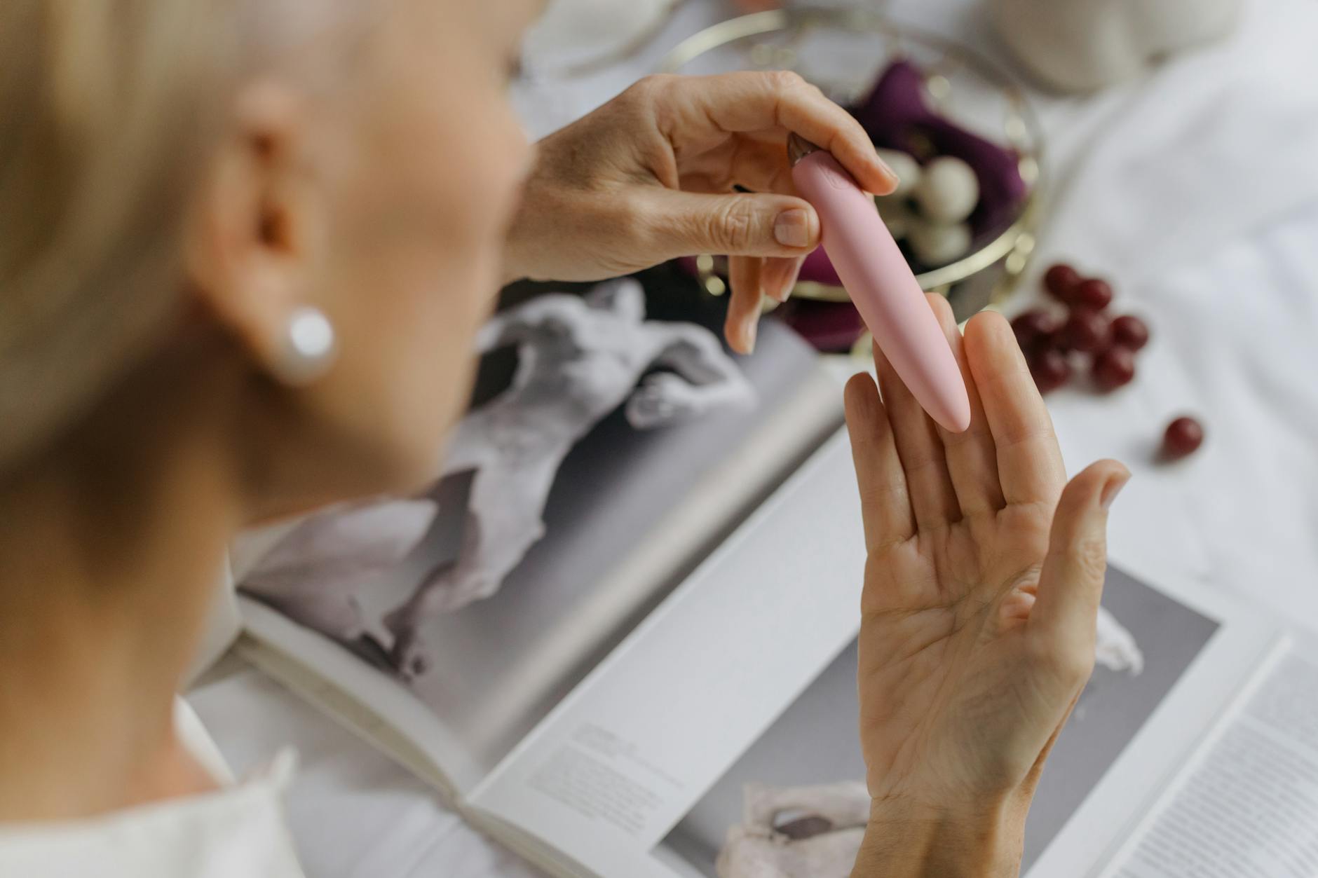 Close-up of hands holding a pink vibrator, emphasizing intimate reconnection between partners.