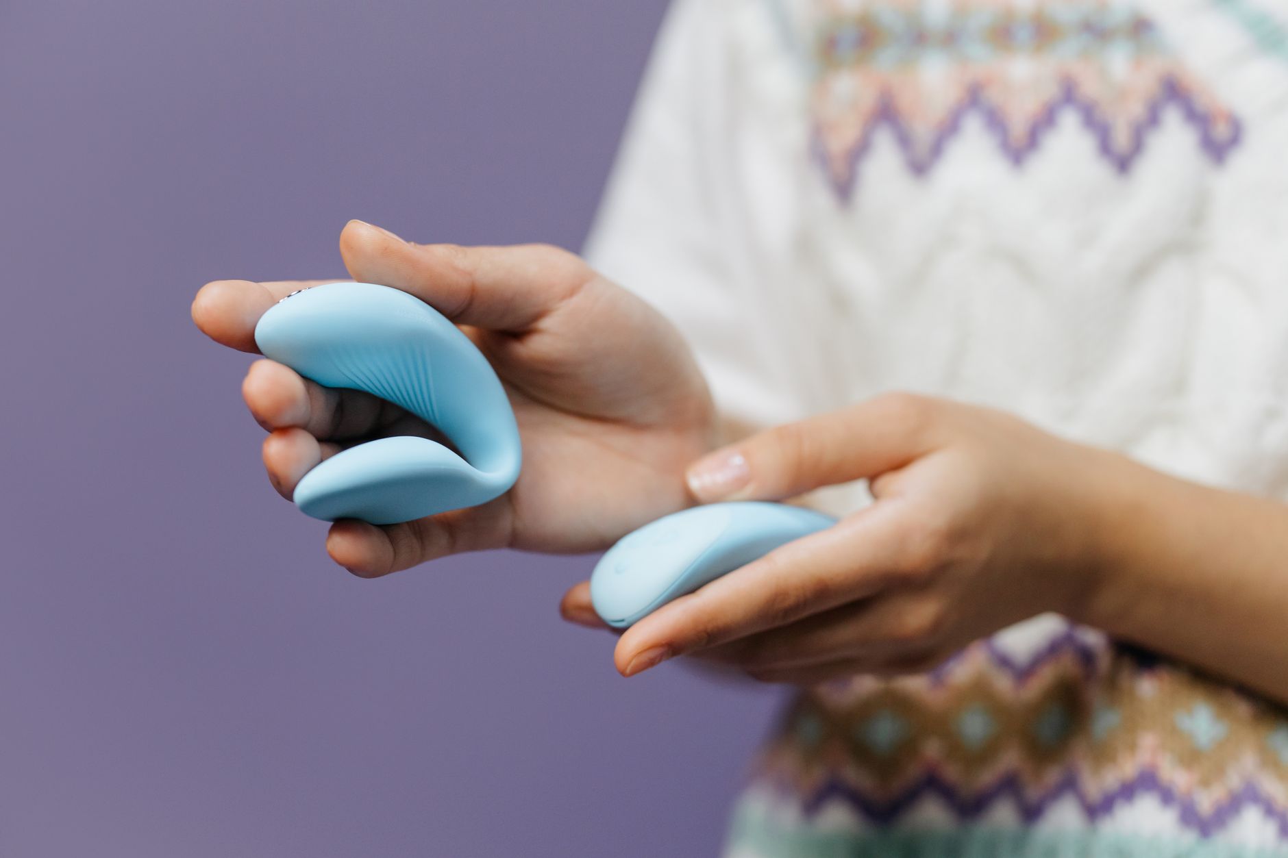 Close-up of hands holding a sleek blue vibrator, illustrating accessible grip techniques.
