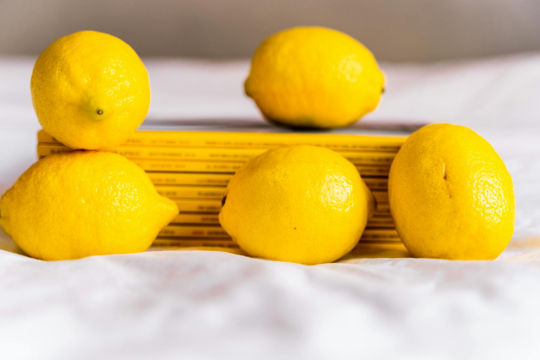 Fresh lemons arranged on a white surface, symbolizing the natural approach to pleasure